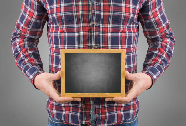 istock A man without a head with a black board in his hands on a gray background 1227630476