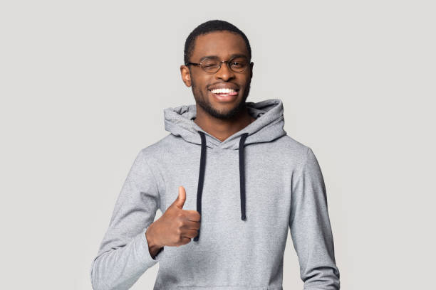 istock African guy showing thumbs up pose isolated on gray background 1227633045