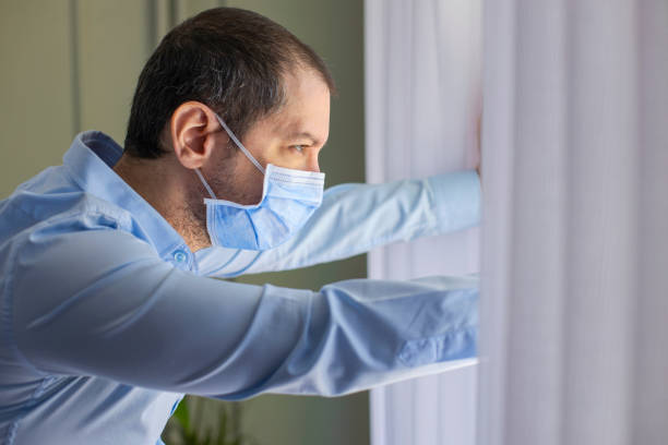 istock Young man in isolation at home near window 1227634395