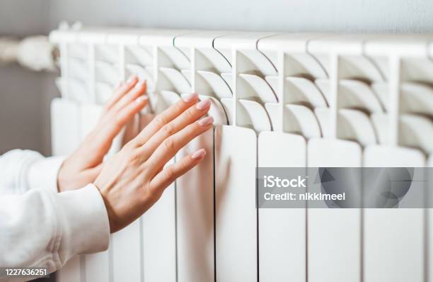 Woman Warms Up Hands Over Heater Stock Photo - Download Image Now - Radiator - Heater, Heat - Temperature, Electric Heater