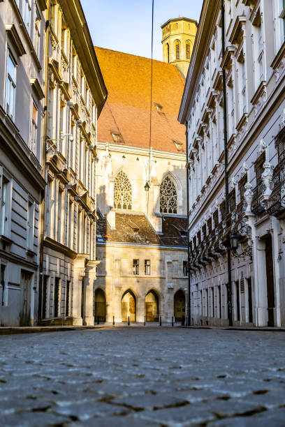 A deserted street with paving stones and sunlight in front. Vertical orientation. High quality photo.