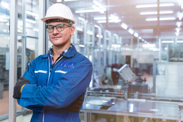Portrait of manual man worker is standing with confident with blue working suite dress and safety helmet in front the glass wall of high technology clean industry factory. retrato de hombre manual trabajador está de pie con confianza con vestido de suite de trabajo azul y casco de seguridad en frente de la pared de vidrio de la fábrica de la industria limpia de alta tecnología. concepto de trabajador de la industria intel