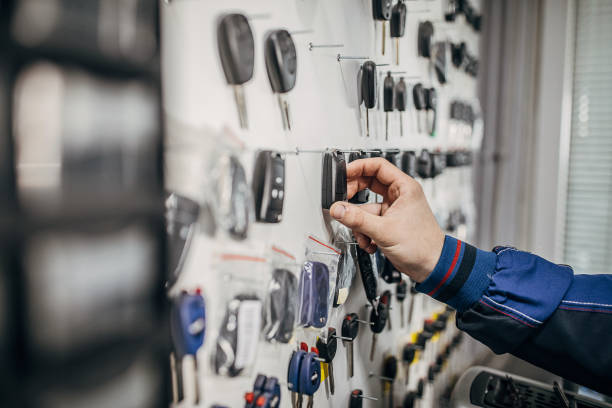 istock Locksmith stand with car keys on hooks, human hand taking the key 1227652449