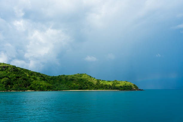 Tropical green Island with storm clouds in the background