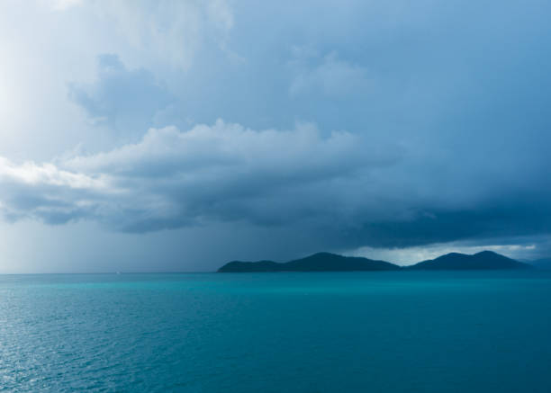Islands in a blue sea with tropical storm clouds approaching