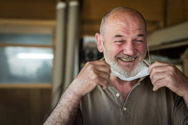 hombres artesanos 60-65 años en su taller sonriendo después del aislamiento, tiro en la cabeza - foto de stock - senior adult 60 65 years people occupation fotografías e imágenes de stock