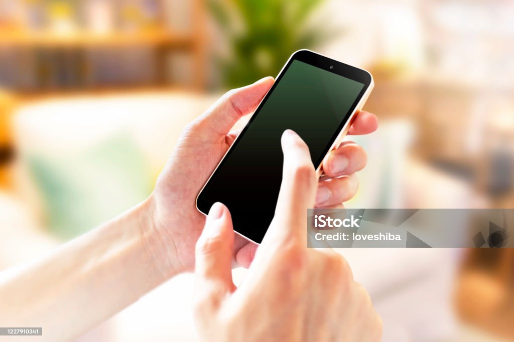 屋内スマートフォンの操作のイメージ 5238 - スマートフォンのロイヤリティフリーストックフォト 屋内スマー��トフォンの操作のイメージ 5238 - スマートフォンのロイヤリティフリーストックフォト