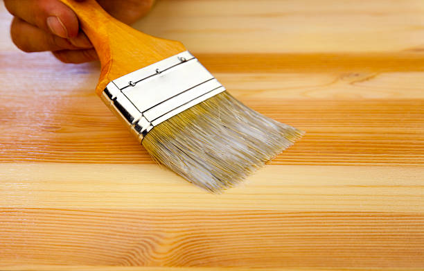 istock Wood texture, human hand and paintbrush / housework background 122799934
