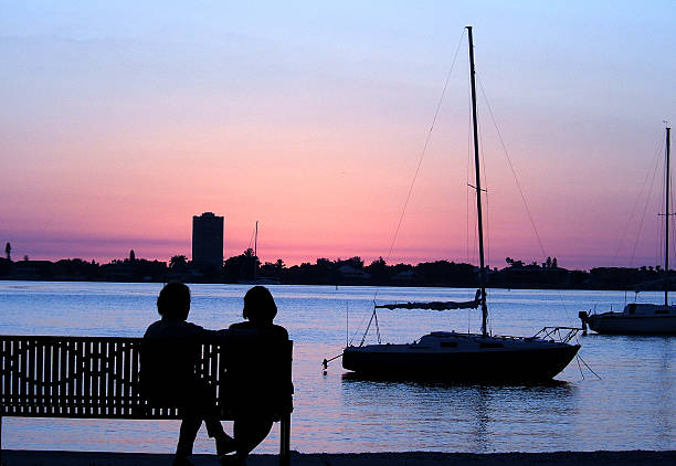 A silhouette of a couple and boats stock photo