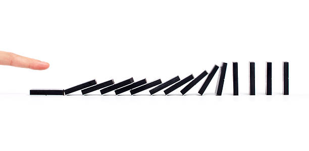 istock Finger pushing dominoes in a row causing chain reaction 122811745