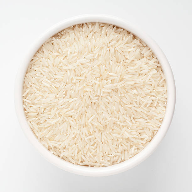 istock Uncooked basmati rice in a ceramic bowl on white background 122813200