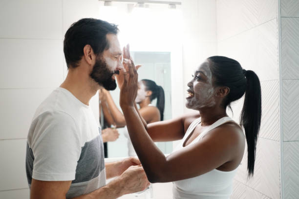 женщина применения красоты маска и кожа моющее средство для человека - cosmetics applying moisturizer women стоковые фото и изображения