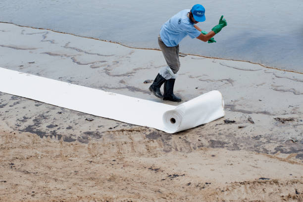 trabalhadores e voluntários removem e limpam o petróleo bruto derramado com papel absorvente. - oil slick pouring chemical oil - fotografias e filmes do acervo