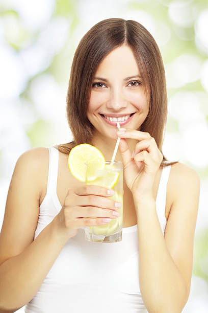 fille tenant une limonade - water women glass healthy eating photos et images de collection