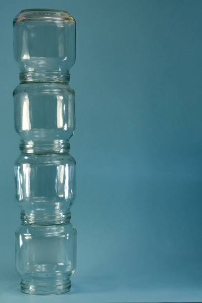 istock Vertical row of glass four jars on the left on a blue background, vertical frame. 1228288848