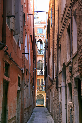 Typical narrow street with historical houses in Venice. Narrow pedestrian streets of Venice between the channels. Some quiet places almost without people.