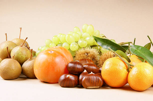 Assortment of autumn fruits over a light brown background