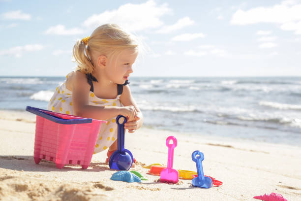 sommerurlaub. entzückende kleinkind mädchen spielen mit strand spielzeug am sandstrand. - lifestyles child beach digging stock-fotos und bilder