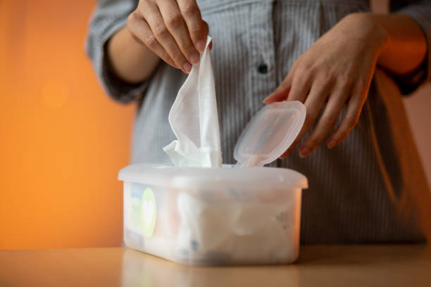 istock Wet wipes are universal an practical: woman take one wipe from big plastic box package for cleaning 1228561629