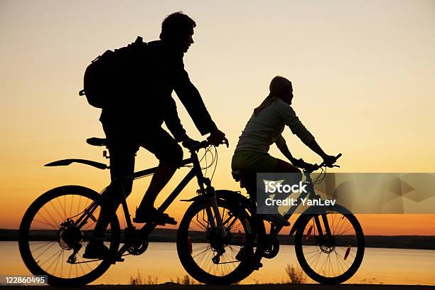 Młoda Para Jazdy Rowerami Na Zachód Słońca - zdjęcia stockowe i więcej obrazów Bicykl - Bicykl, Dwie osoby, Jeździć na rowerze