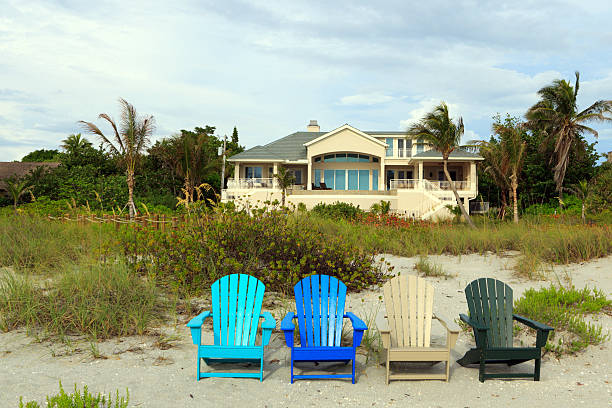 giallo spiaggia casa con sedie colorate - casa al mare foto e immagini stock