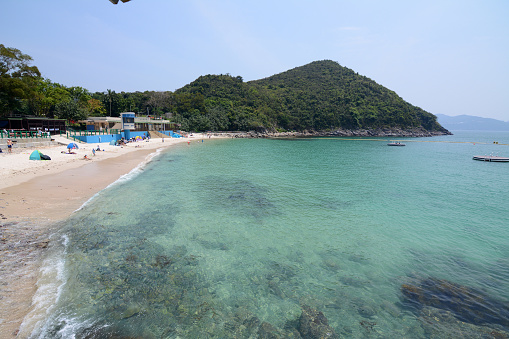 People sunbathing at idyllic Hap Mun bay, Sharp island, the largest island in the Kiu Tsui Country Park located at Port Shelter of Sai Kung, Hong Kong. Sharp Island is under the administration of Sai Kung District