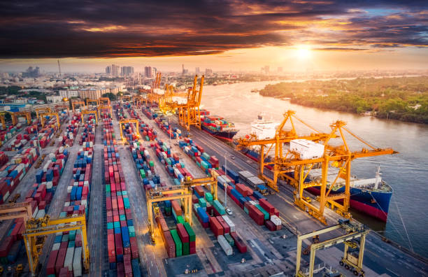 istock Logistics and transportation of Container Cargo ship and Cargo plane with working crane bridge in shipyard at sunrise, logistic import export and transport industry background 1228788369
