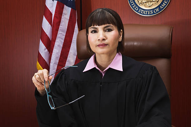 Asian Female Judge Seated in Courtroom stock photo