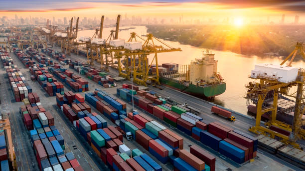 istock Logistics and transportation of Container Cargo ship and Cargo plane with working crane bridge in shipyard at sunrise, logistic import export and transport industry background 1228960062