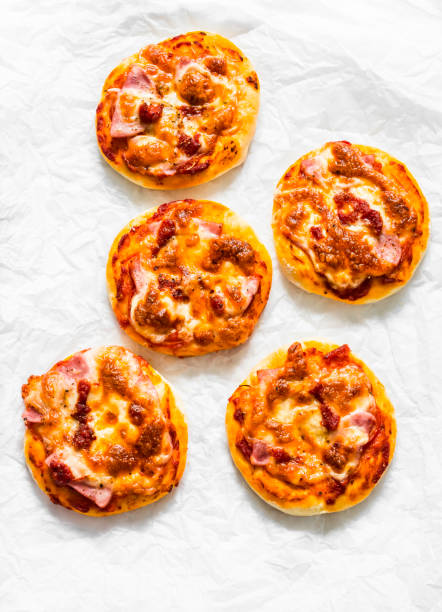 istock Ham, tomato sauce, mozzarella pizza on a light background, top view. Delicious breakfast, snack, tapas 1229145045