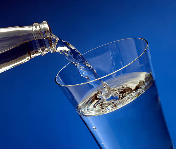 Pouring water in glass stock photo