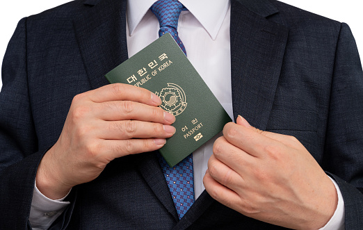 Korean businessman holding a Korean passport in hand.