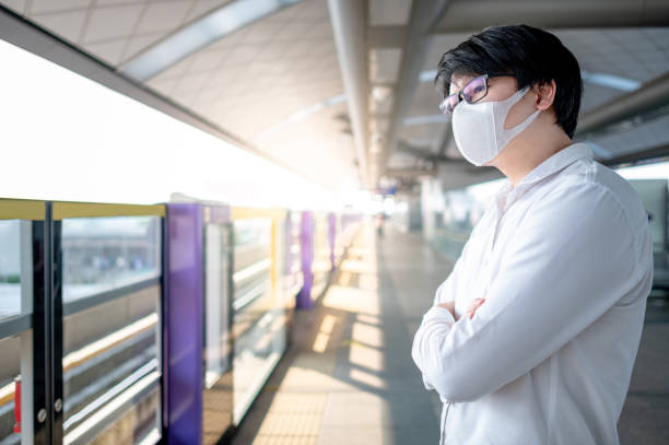 istock Asian man wearing mask at skytrain station 1229384284