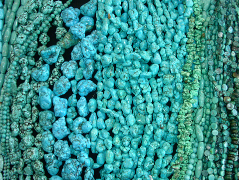 Many strands of turquoise beads for sale at a market.