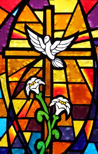 Beautiful stained glass panel found in a very old, very small church depicting the dove of peace and containing a cross and lilies. 