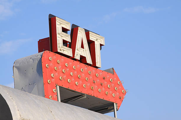 Retro restaurant sign that says EAT on red arrow Retro sign from an old diner is photographed against a blue sky. 1950s diner stock pictures, royalty-free photos & images