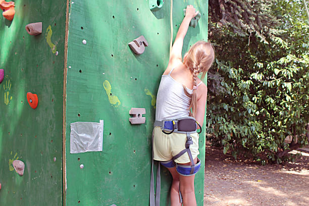 istock girl on the climbing wall with insurance 1229539189