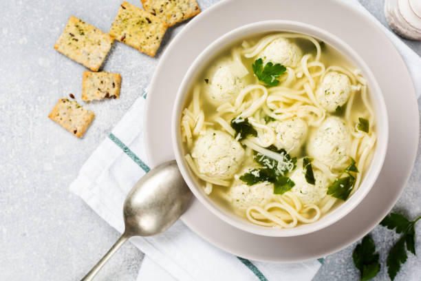istock Soup with chicken meatballs and egg paste, Parmesan cheese, parsley in a ceramic bowl on a gray table background. Traditional Italian broth.  Top view. 1229547258