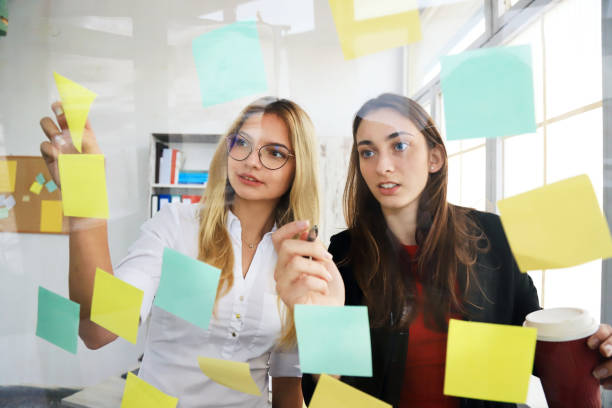 istock Two businesswomen looking at sticky notes 1229674538