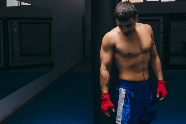 istock Personal boxing coach waiting for his trainees in dark boxing studio 1229742878