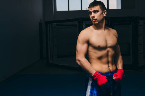 istock Personal boxing coach waiting for his trainees in dark boxing studio 1229776443