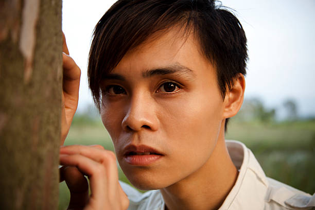 Young Man Posing Next To A Tree stock photo