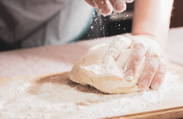 istock Knead the dough on a wooden board at home 1229793670
