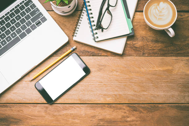 istock top view Office equipment including Laptop, mobile phone, mouse, notebook, coffee cup on the wood floor 1229819647