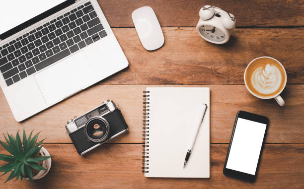 istock top view Office equipment including Laptop, mobile phone, mouse, notebook, coffee cup on the wood floor 1229819880