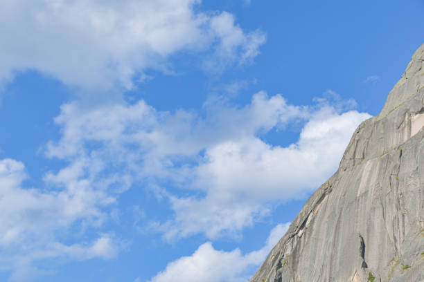 peak under blue sky with clouds, preparation for climbing rock ridge, journey in mountain valley