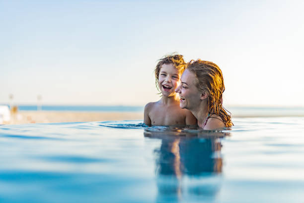istock Cheerful single mother and her boy in the pool. 1229935430