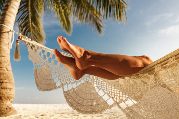 istock Unrecognizable woman's legs from a hammock on the beach. 1229945547