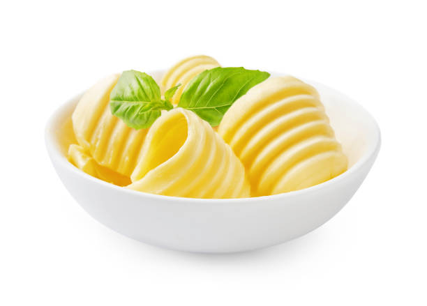 istock Butter curls or butter rolls in white bowl with fresh basil leaves isolated on white background. 1229988977
