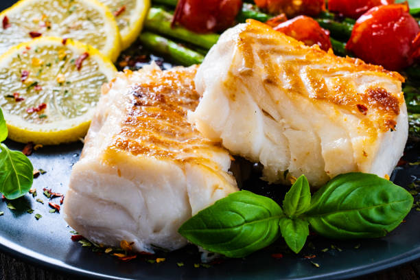 filete de bacalao frito con verduras frescas - pez magro fotos fotografías e imágenes de stock